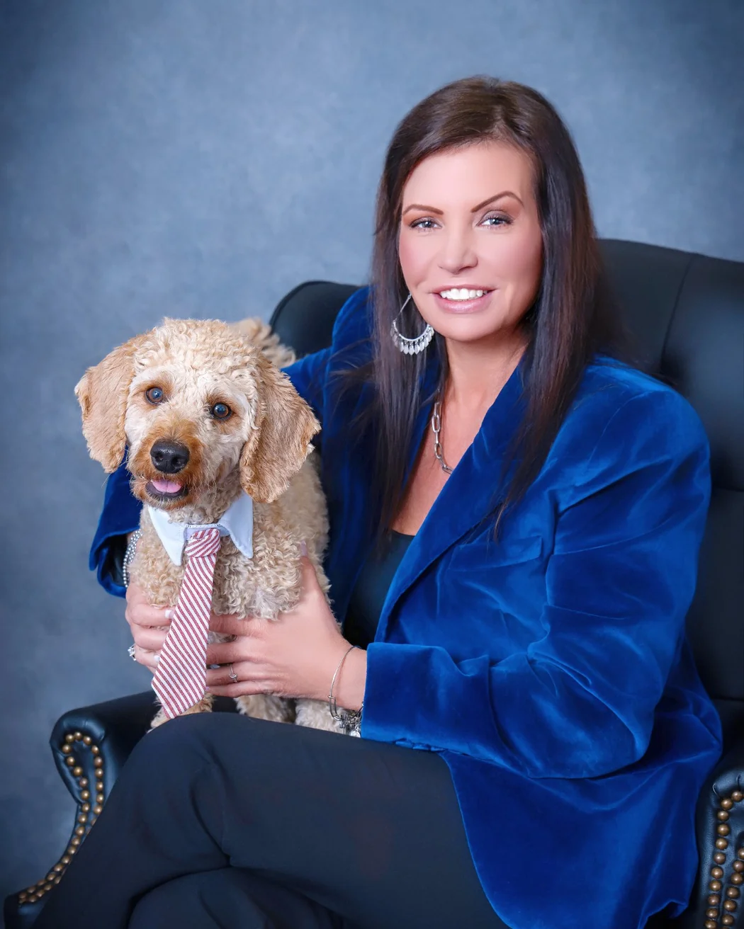 Carolyn Eichenhofer seated in a blue blazer with her dog Obi